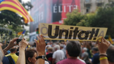 Un manifestant aixeca un cartell on posa "unitat!" repartit per membres de la Crida per la República durant la manifestació del segon aniversari dels escorcolls a la seu del Departament d'Economia. Ander Zurimendi