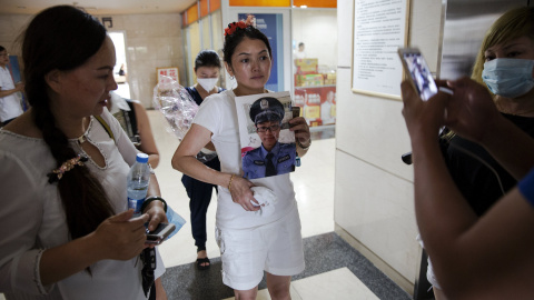 Una mujer trata de encontrar a su hijo, uno de los bomberos desaparecidos, enseñando su foto en un hospital. REUTERS