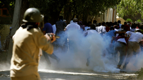 Manifestantes huyen ante un policía que dispara gases lacrimógenos durante una manifestación contra los recientes asesinatos en Cachemira, en las afueras de Srinagar. REUTERS/Danish Ismail