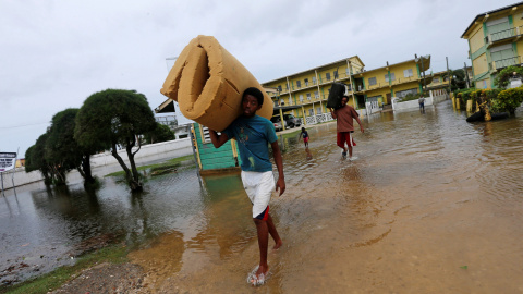 Un hombre lleva un colchón mientras abandona una escuela que ha usado como refugio  después del huracán Earl que ha golpeado en la ciudad de Belice, en Belice. REUTERS / Henry Romero