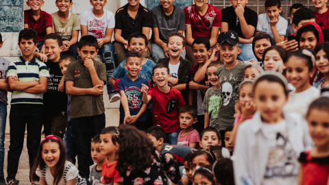 Los niños palestinos ríen durante la actuación de Ivan Prado. BERNAT ALMIRALL.