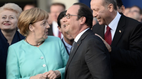 La canciller alemana, Angela Merkel, conversa con el presidente turco, Recep Tayyip Erdogan , en presencia del mandatario francés, François Hollande, durante un cumbre de la OTAN el pasado 8 de julio. - AFP