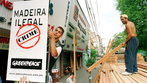 Un activista coloca un cartel que denuncia la extracción ilegal de madera en el Amazonas. AFP/MARIE HIPPENMEYER