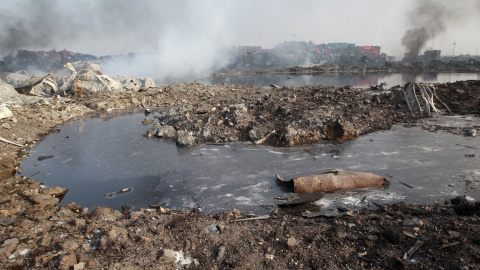 Pequeño lago de un líquido indeterminado en la zona, todavía humeante, de las explosiones producidas el pasado miércoles en Tianjin. - REUTERS