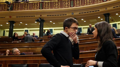 Los diputados de Podemos Iñigo Errejón e Irene Montero conversan en el hemiciclo del Congreso.- EFE