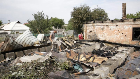 Varios lugareños revisan los restos de un edificio tras un bombardeo en la ciudad de Donetsk (Ucrania) este 17 de agosto de 2015. Al menos dos soldados ucranianos murieron y y otros siete resultaron heridos en las últimas 24 horas en accion