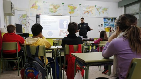 Alumnos atienden a una charla sobre acoso escolar impartida por un agente de Policía.