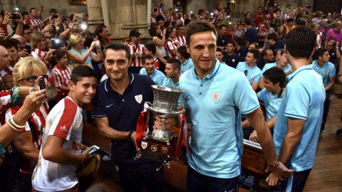 El capitán del Athletic de Bilbao, Carlos Gurpegui, y el entrenador del equipo, Ernesto Valverde, durante la ofrenda de la Supercopa a la Virgen de Begoña, patrona de Bilbao, con la que se han inciado los actos de homenaje que recibe hoy el