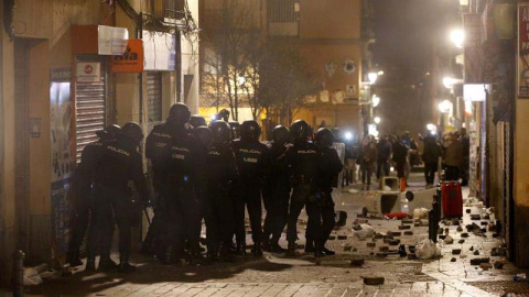 Policías antidisturbios en la calle Mesón de Paredes con la calle del Oso, en el barrio de Lavapiés de Madrid, repelen las protestas tras la muerte de un mantero de un paro cardíaco durante un control policial. | JAVIER LIZÓN (EFE)