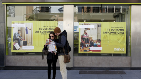 Dos turistas consultan un mapa frente a una oficina de Bankia en Sevilla. REUTERS/Marcelo del Pozo