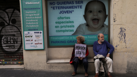 Manifestantes, con un cartel que demanda "Pensión justa, ahora", sentados junto a una clínica en Madrid. REUTERS / Susana Vera