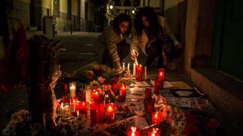 Dos jóvenes depositan velas en el lugar donde murió el mantero senegalés Mmame Mbage. JAIRO VARGAS