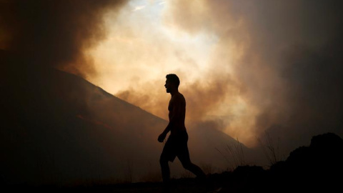 Un ciudadano observa un incendio forestal producido en la localidad Cortegaça de Arouca, Portugal. EFE/Estela Silva