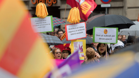 Varias personas muestra pancartas en la manifestación celebrada hoy por el centro de Barcelona bajo el lema: "¡Ahora nos toca a nosotros! + igualdad, + empleo + salarios + pensiones", en favor de unas pensiones y salarios dignos en la tradi