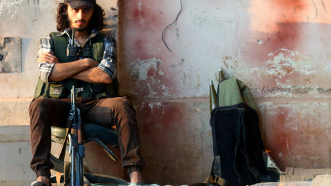 Un soldado rebelde se sienta abrazado a su arma en la academia de artillería de Alepo, Siria. REUTERS/Ammar Abdullah