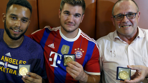 Los hombres que ayudaron a desarmar al presunto terrorista Anthony Sadler, Aleck Sharlatos y Chris Norman, posan con las medallas que recibieron por su valentía en un restaurante en Arras, Francia.-REUTERS