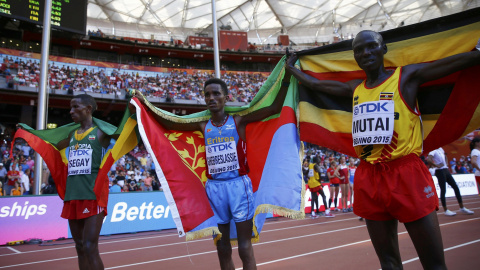 El ganador de la maraton del Mundial de Atletismo, en Pekón, el eritreo Ghirmay Ghebreslassie, entre el segundo clasificado, el etíope Yemane Tsegay (izq) y el ugandés Munyo Solomon Mutai (der). REUTERS/Kai Pfaffenbach