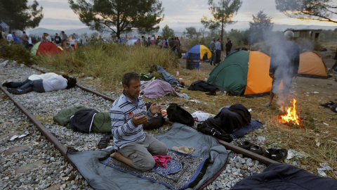 Un refugiado sirio reza sobre la vía férrea en la frontera entre Grecia y Macedonia, cerca del pueblo de Idomeni.- REUTERS