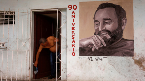 Un hombre en la puerta de su vivienda en La Habana, en cuya fachada tiene pintado un retrato de Fidel Castro. REUTERS/Stringer