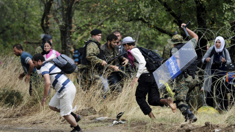 La Policía carga contra los refugiados, que rompen el cordón para cruzar de Grecia a Macedonia.-REUTERS/Ognen Teofilovski