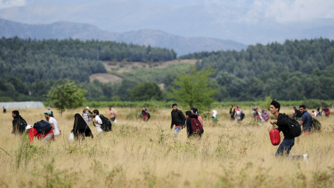 Los refugiados que rompen el cordón corren en los campos de territorio de Macedonia hacia la ciudad de Gevgelija, donde cogerán un tren a Serbia.- REUTERS/Ognen Teofilovski