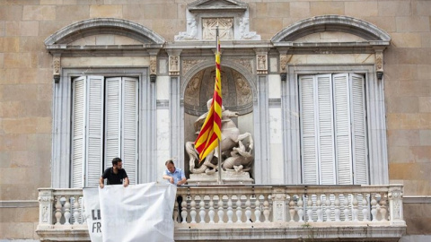 El moment en què personal de la Generalitat retira la pancarta amb el llaç groc. EUROPA PRESS / AVID ZORRAKINO