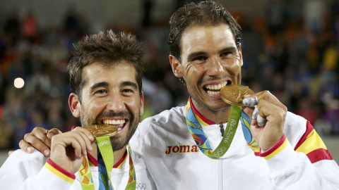 Los tenistas españoles Rafael Nadal y Marc López muerden la medalla de oro ganada hoy en la final de tenis de dobles masculino en los Juegos Olímpicos de Brasil 2016. REUTERS/Kevin Lamarque