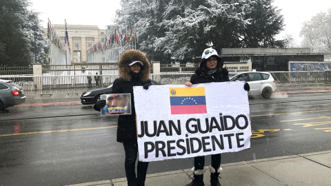 Dos venezolanas sujetan una pancarta en apoyo al líder opositor de Venezuela Juan Guaidó ante la sede europea de Naciones Unidas en Ginebra. / EFE - ANTONIO BROTO