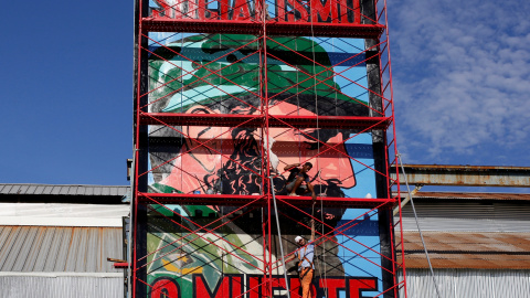 Un hombre pintanto un cartel con el retrato de Fidel Castro con el rótulo 'Socialismo o Muerte', en La Habana. REUTERS/Stringer