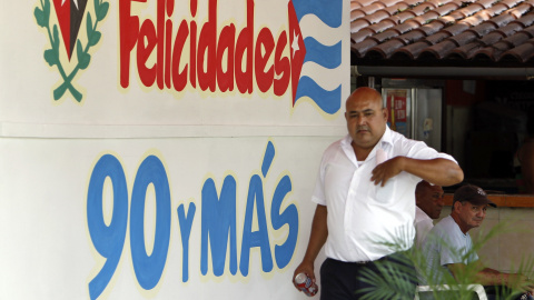 Un hombre pasa en La Habana (Cuba) junto a un mensaje alusivo al cumpleaños 90 del líder de la revolución cubana Fidel Castro. EFE/Ernesto Mastrascusa