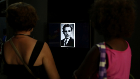 Un par de personas observan un retrato de Fidel Castro joven, que forma parte de la exposión 'Fidel', con motivo del 90 cumpleaños del líder de la revolución cubana. REUTERS/Alexandre Meneghini