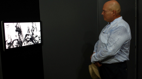 Alex Castro, fotógrafo e hijo de Fidel Castro, observa una foto del líder de la revolución cubana con su hermano, el actual presidente Raúl Castro, en la exposición 'Fidel', con motivo de su 90 cumpleaños. REUTERS/Alexandre Meneghini