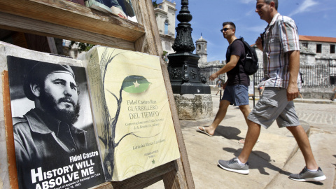 Un hombre camino junto a libros exhibidos dedicados al líder de la revolución cubana Fidel Castro con motivo de su 90 cumpleaños. EFE/Ernesto Mastrascusa