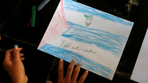 Una niña cubana pinta una bandera cubana y al líder de la revolución cubana, Fidel Castro, con la frase 'Fidel entre nosotros', en uno de los actos organizados en Expocuba con motivo de su 90 cumpleaños. REUTERS/Stringer