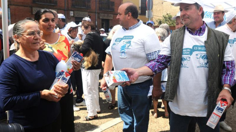 El presidente de ASAJA, Donaciano Dujo, reparte leche a su llegada de la "Marcha Blanca " de los ganaderos del sector lácteo a la localidad de Mansilla de las Mulas, en la primera etapa de esta protesta por la crisis del sector, que llegará