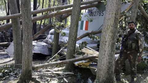 Un soldado indio al lado de los restos de un avión de las Fuerzas Aéreas en Soibugh en Budgam a unos 15 km de Srinagar (India), 24 de agosto de 2015. No se han producido daños personales en el accidente ya que el piloto consiguió eyectarse 