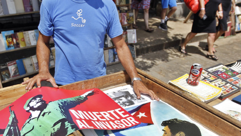 Un hombre expone varios carteles del líder de la revolución cubana Fidel Castro, con motivo de su 90 cumpleaños. EFE/Ernesto Mastrascusa