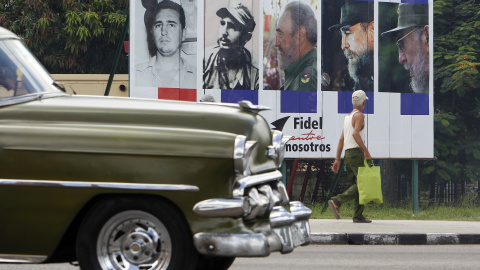 Un vehículo pasa en La Habana junto a un cartel alusivo al cumpleaños 90 del líder de la revolución cubana Fidel Castro. EFE/Ernesto Mastrascusa