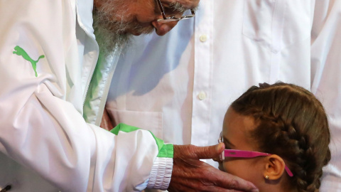 El líder cubano Fidel Castro saluda a una niña durante el acto oficial de celebración de sus 90 años en el Teatro Karl Marx de La Habana. EFE