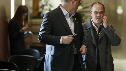 El diputado de Junts per Catalunya, Jordi Turull (i), junto al portavoz parlamentario del grupo, Eduard Pujol (d), en los pasillos del Parlament. /EFE