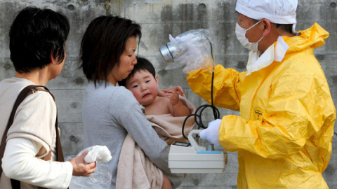 Personal médico comprueba los niveles de radiación de una mujer y su hijo en Kawamata en la región de Fukushima (Japón). / EFE