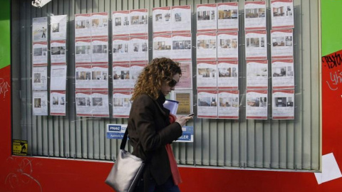 Una joven pasa por delante de una oficina inmobiliaria en el centro de Madrid. REUTERS/Andrea Comas