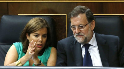 El presidente del Gobierno, Mariano Rajoy (d), y la vicepresidenta, Soraya Sáenz de Santamaría (i), conversan durante el segundo día del debate de totalidad del proyecto de Ley de Presupuestos para 2016, en el pleno del Congreso. EFE/Sergio