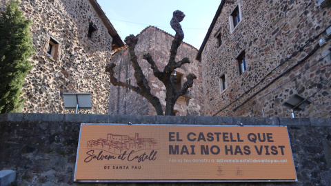 El marcador electrònic amb el castell de Santa Pau al fons