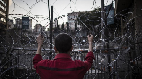 Un hombre agarra el alambre de espino que bloquea el acceso a la sede del Gobierno en Beirut, Líbano, hoy 26 de agosto de 2015. En los últimos días, miles de personas han salido a las calles de la capital del país para protestar por la cris