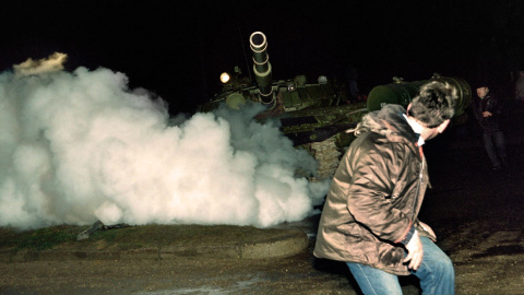 Un manifestante lituano corre frente a un tanque del ejército soviético durante el asalto a la estación de radio y televisión lituana el 13 de enero de 1991. AFP