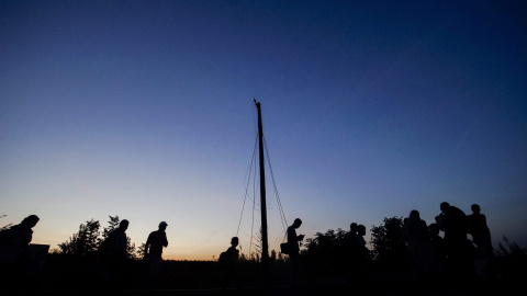 Varios refugiados caminan por la línea férrea, cerca de Roszke, Hungría, para cruzar su frontera con Serbia.- EFE/Zoltan Balogh