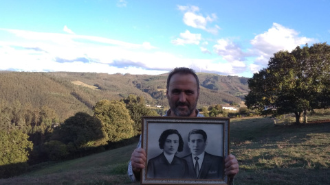 Pedro Amago sujeta el retrato del alcalde socialista Clemente Amago y su mujer, Regina Llenderozos.