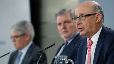 El portavoz del Gobierno y ministro de Educación, Íñigo Méndez de Vigo (c), junto al ministro de Hacienda, Cristóbal Montoro (d) y el ministro de Asuntos Exteriores, Alfonso Dastis (i), durante la rueda de prensa posterior a la reunión del 