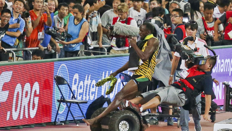 Bolt es arrollado por un cámara durante su celebración.-REUTERS